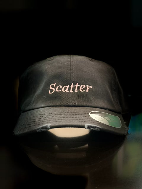 Black Scatter dad hat with “Scatter” embroidered in pink on the front and a distressed brim