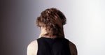 Hands running Scatter Slip serum through textured hair